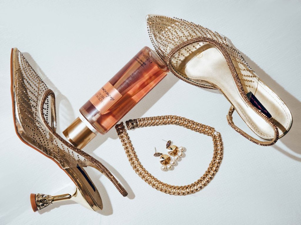 Stylish flat lay of bridal shoes, perfume, and jewelry on a light background.